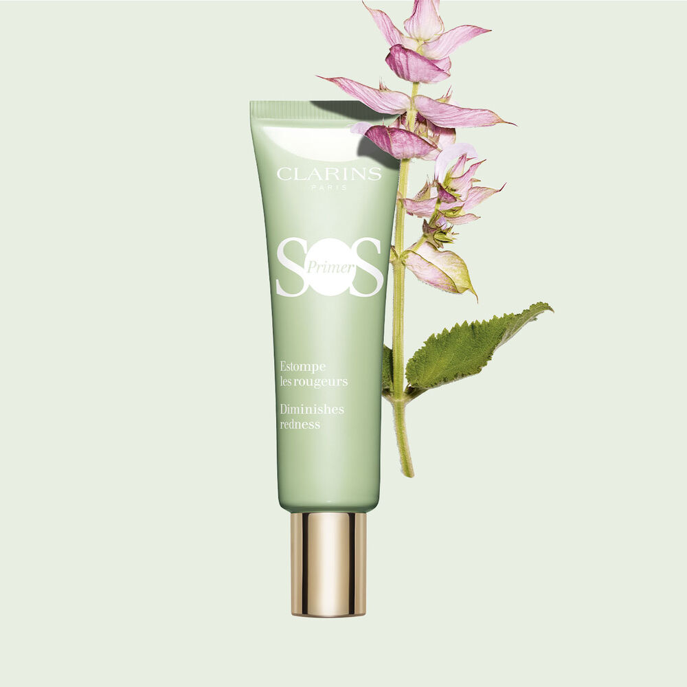 Pakkebilde av en tube med SOS Primer Green fra Clarins for å redusere rødhet med en gren med muskatsalvie