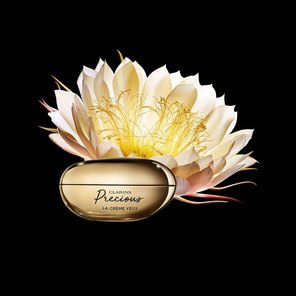 Pakkebilde av Clarins Precious Eyes &oslash;yekrem i n&aelig;rheten av blomsten nattens dronning mot en m&oslash;rk bakgrunn.