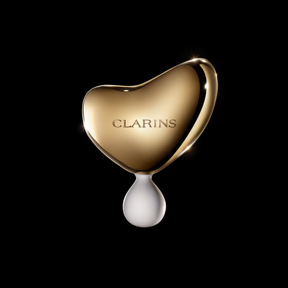 Bilde av Clarins Precious massasjeverktøy mot en mørk bakgrunn.