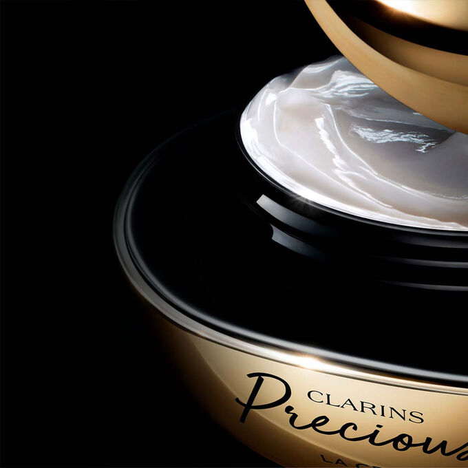 Pakkebilde av Clarins Precious Soft Cream mot en m&oslash;rk bakgrunn med tekst som fremhever kraften til &aring; f&aring; huden til &aring; se fem &aring;r yngre ut