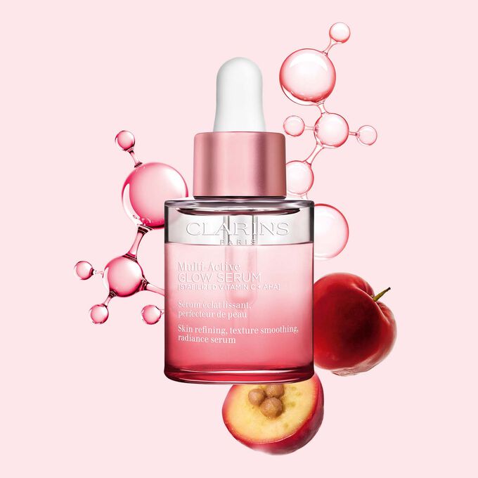 Packshot av Multi-Active Glow Serum med C-vitaminmolekyl og acerola p&aring; en lys rosa bakgrunn, som fremhever hudens gl&oslash;d.