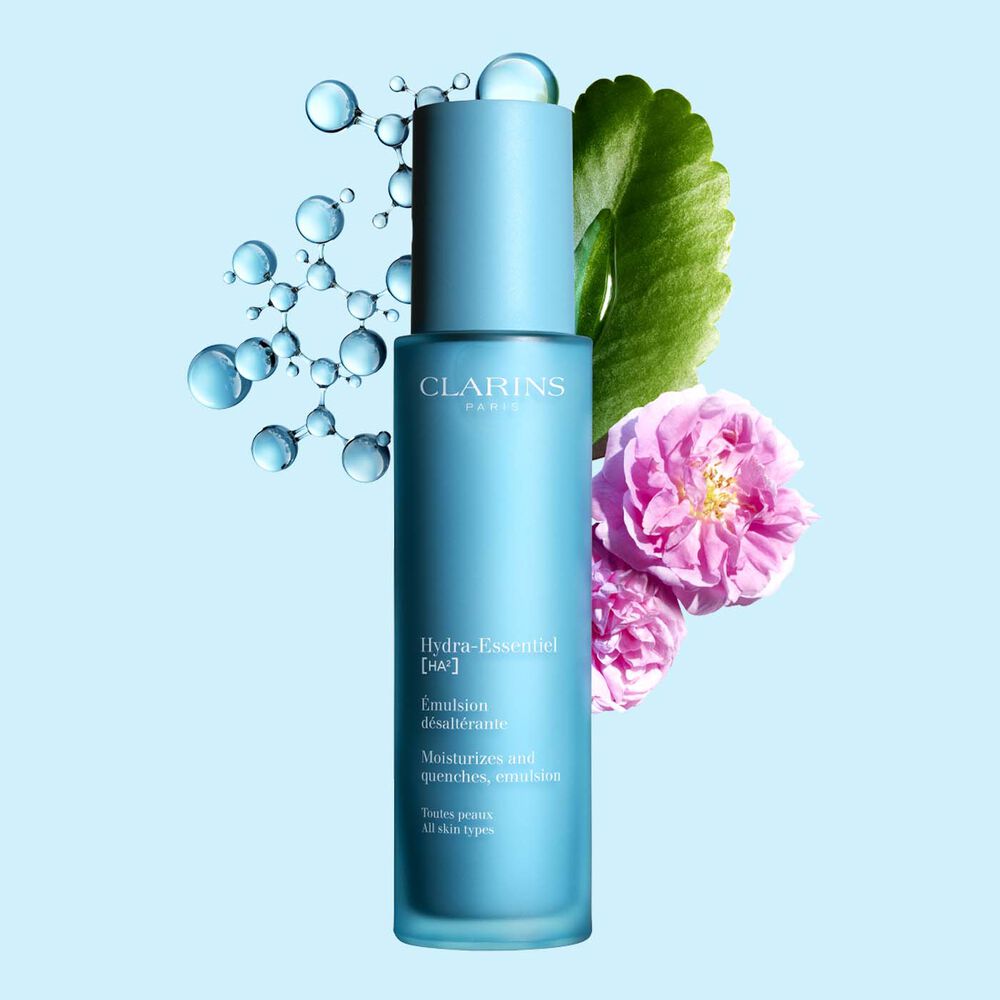 Pakkebilde av Clarins Hydra-Essentiel 23 Emulsion i nærheten av en damaskrose og kalanchoeblad mot en blå bakgrunn.