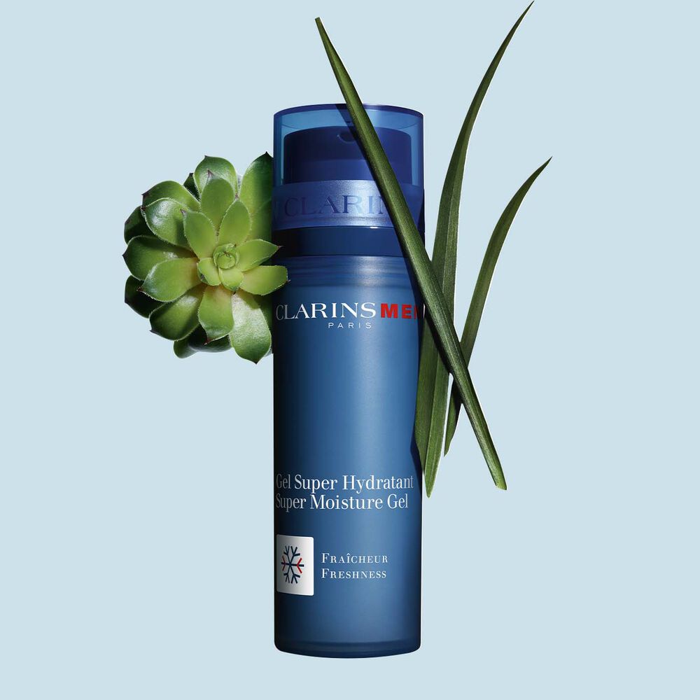 Pakkebilde av en pumpeflaske med Super Moisture Gel fra Clarins i nærheten av gymnena og marigress mot en blå bakgrunn.
