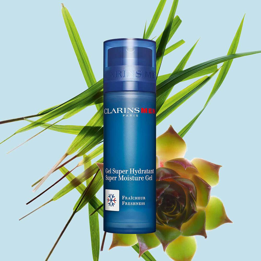 Pakkebilde av en pumpeflaske med Super Moisture Gel fra Clarins i nærheten av gymnena og marigress mot en blå bakgrunn.