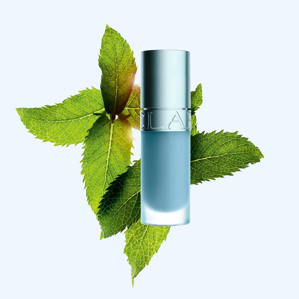 Packshot av Clarins Lip Comfort Oil med ny kj&oslash;lende effekt og glansfull finish, plassert foran mynte for &aring; fremheve n&oslash;kkelingrediensen