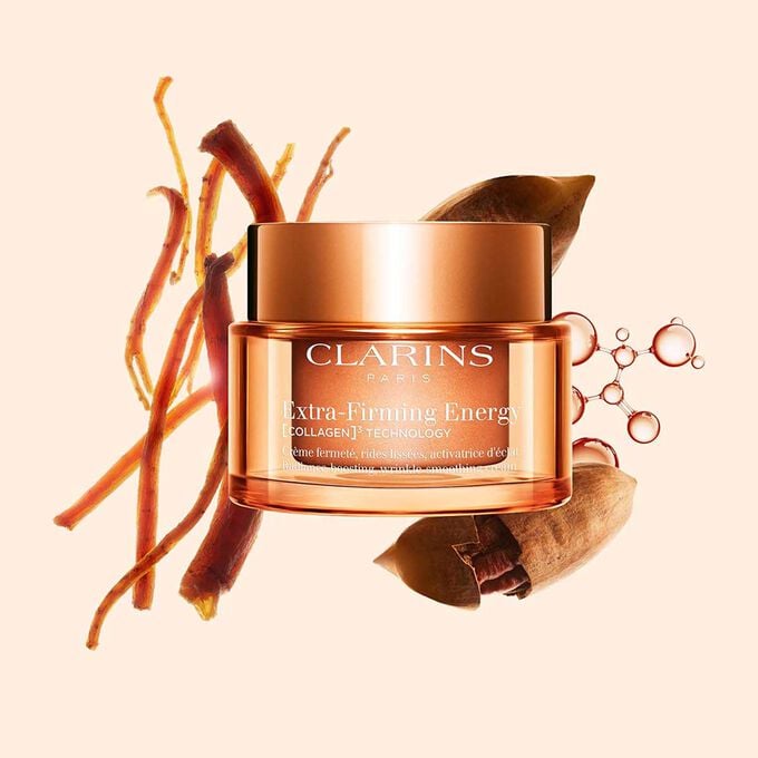 Produktbilde av Extra-Firming Energy-krem fra Clarins ved siden av r&oslash;d ginseng, kollagenmolekyl og mitracarpus mot en beige bakgrunn.