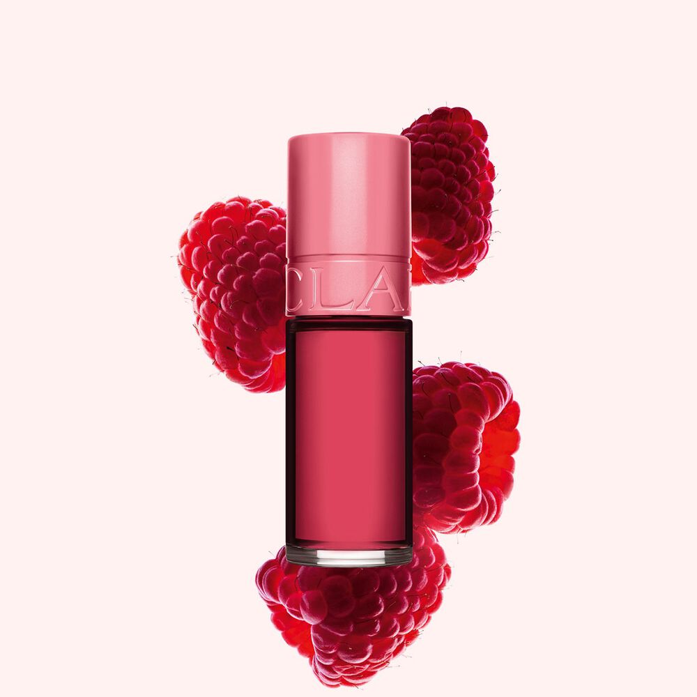 Packshot av Clarins Pink Water Lip Stain i nyanse 11, plassert ved siden av bringebær på en lys rosa bakgrunn.
