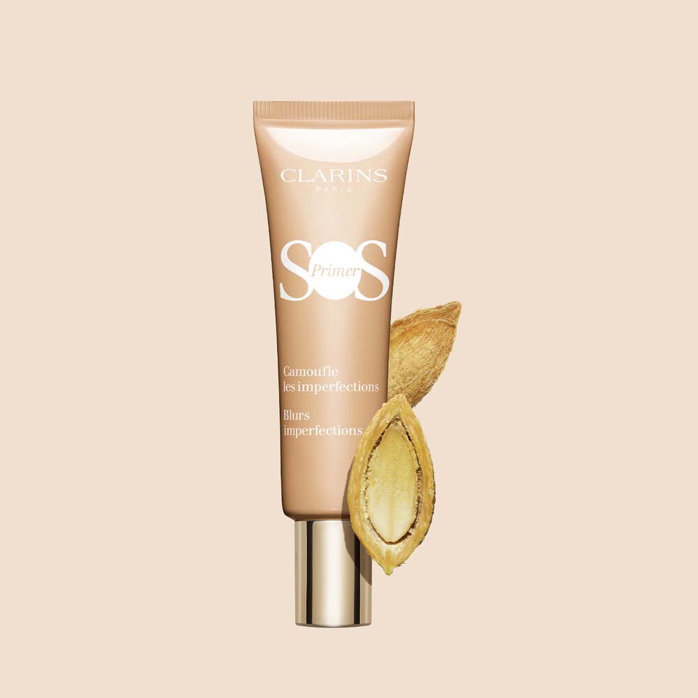 Pakkebilde av en tube med SOS Primer Peach fra Clarins med ørkendaddel som fjerner urenheter og jevner ut hudtonen​