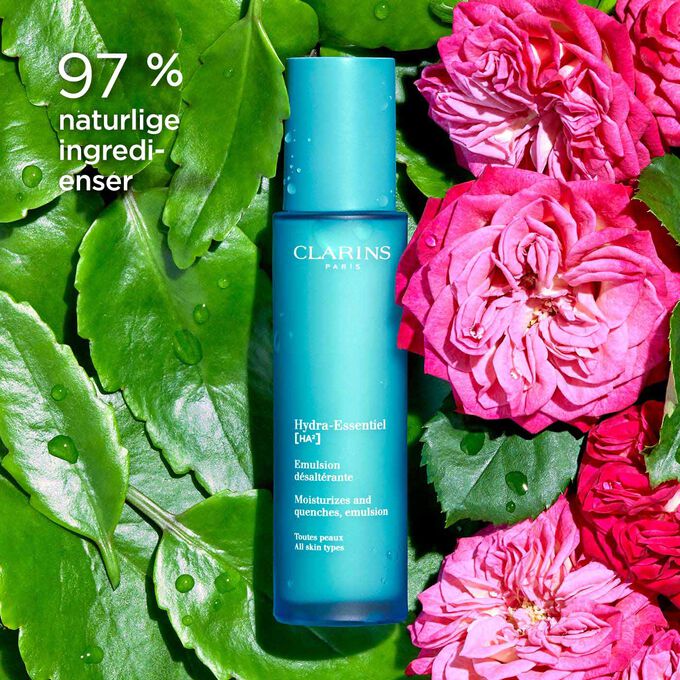 Pakkebilde av Clarins Hydra-Essentiel 23 Emulsion blant damaskroser som fremhever at den inneholder 97 % naturlige ingredienser.