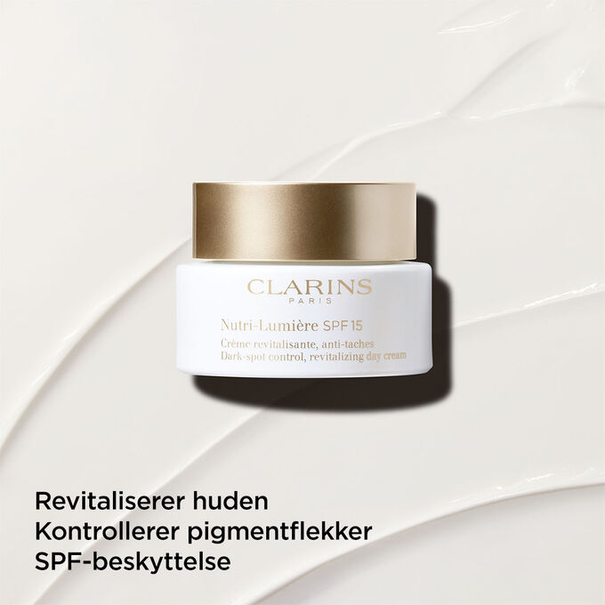 Dagkrem mot pigmentflekker med SPF 15 p&aring; en teksturert bakgrunn som fremhever dens revitaliserende effekt p&aring; huden