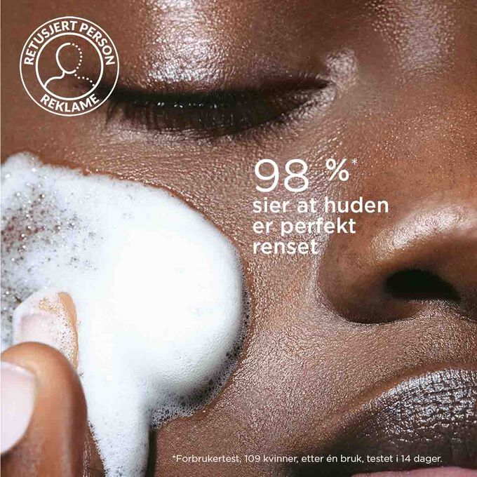 Fokus p&aring; p&aring;f&oslash;ring av en skummende ansiktsrens p&aring; en kvinnes kinn for &aring; illustrere at 98 % av testpersonene opplever at huden er renset.