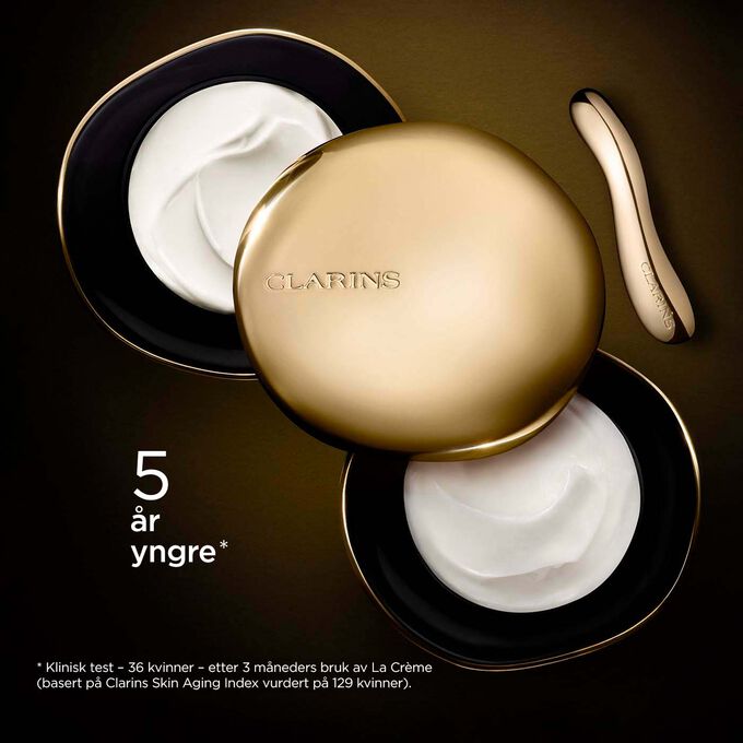 Clarins Precious Rich Cream mot en mørk bakgrunn med tekst som fremhever kraften til å få huden til å se fem år yngre ut