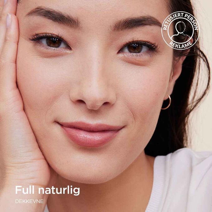 Kvinne som bruker Clarins Skin Illusion Full Coverage foundation og viser full dekkevne med et naturlig resultat.