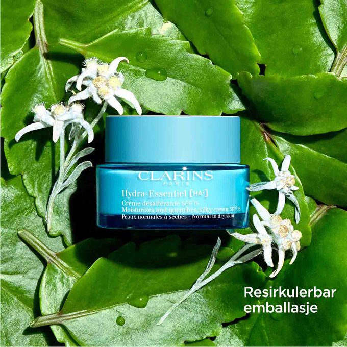 Pakkebilde av Clarins Hydra-Essentiel SPF15 blant blader og edelweissblomster med tekst som fremhever den resirkulerbare emballasjen.
