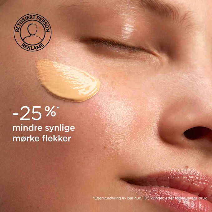 Kvinne med lukkede øyne med SOS Primer Peach fra Clarins på ansiktet for å illustrere at den reduserer mørke flekker med 25 %.